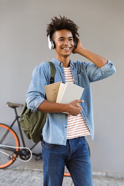 屋外でバックパックを持つ陽気な若い男