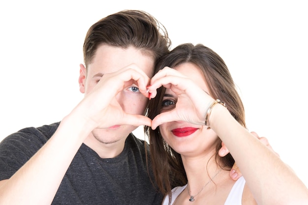 Cheerful young people expressing their love by forming a heart shape