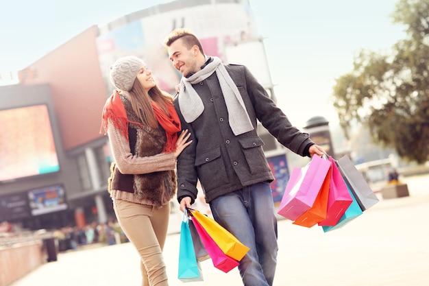 街で買い物袋を持って歩く陽気な若者