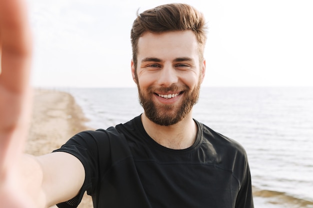 Photo cheerful young sportsman with headphones