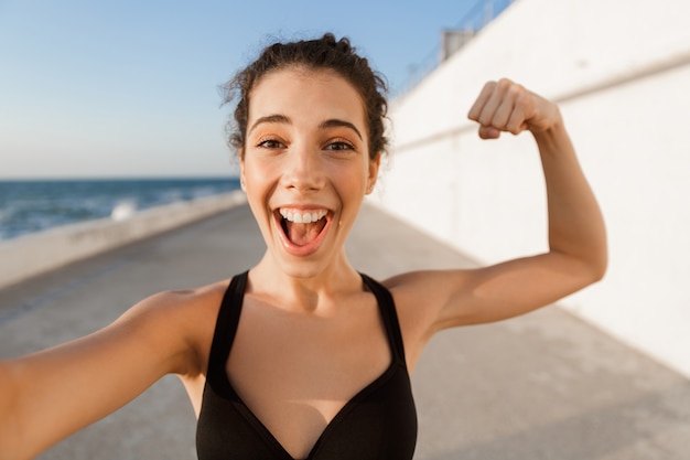 Cheerful young sportswoman standing