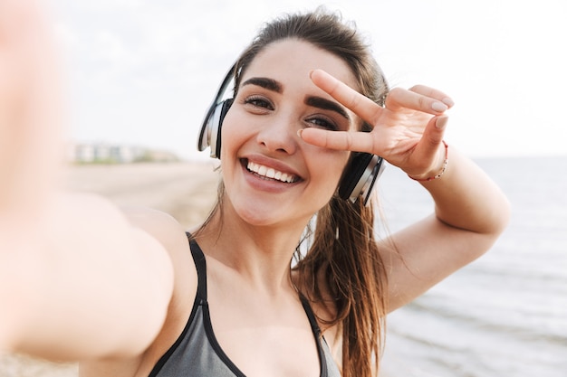 Cheerful young sportswoman with headphones