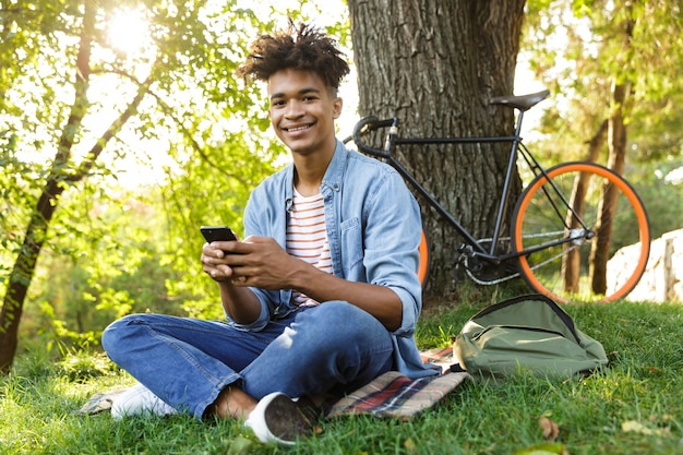 屋外でバックパックを持っている陽気な若いティーンエイジャー