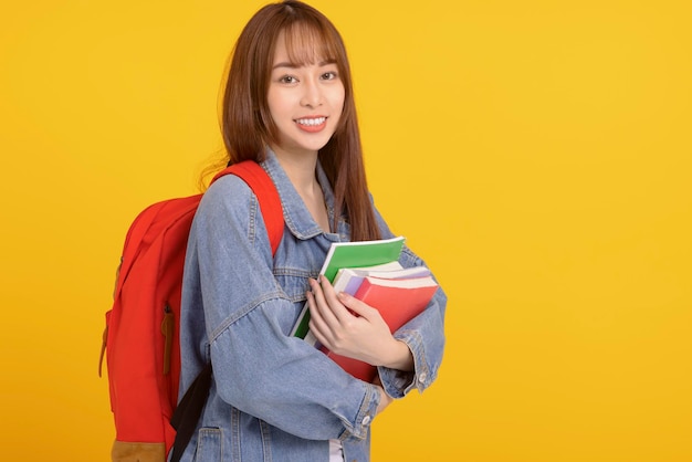 Cheerful young woman college student holding books