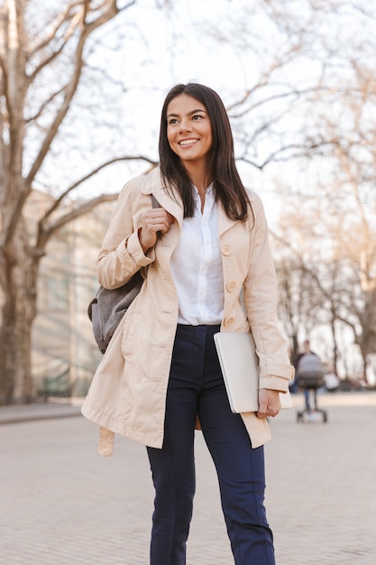 Cheerful young woman dressed in autumn coat