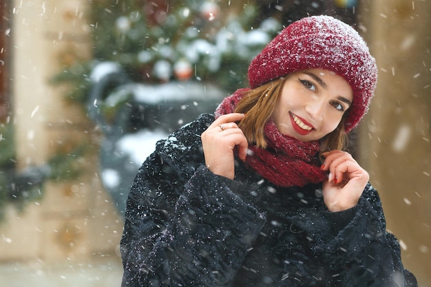 クリスマス休暇中に降雪を楽しんでいる陽気な若い女性。テキスト用のスペース