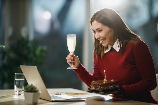 Cheerful young woman have online birthday celebration at home during Covid-19 isolation.