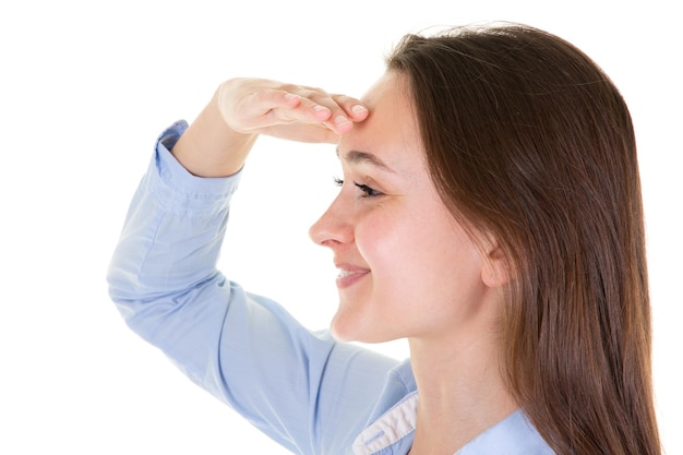 Cheerful young woman is trying to see something hand forehead