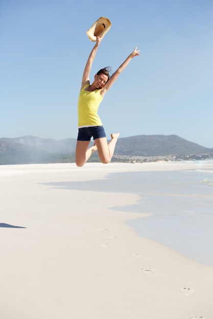 Cheerful young woman jumping at the seashore