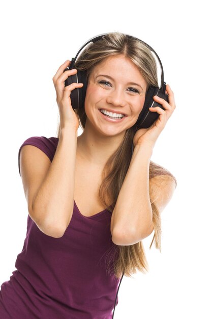 Cheerful young woman listening music with headphones on white