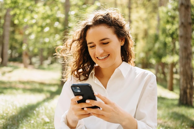 Cheerful young woman received a wonderful message on the phone while walking