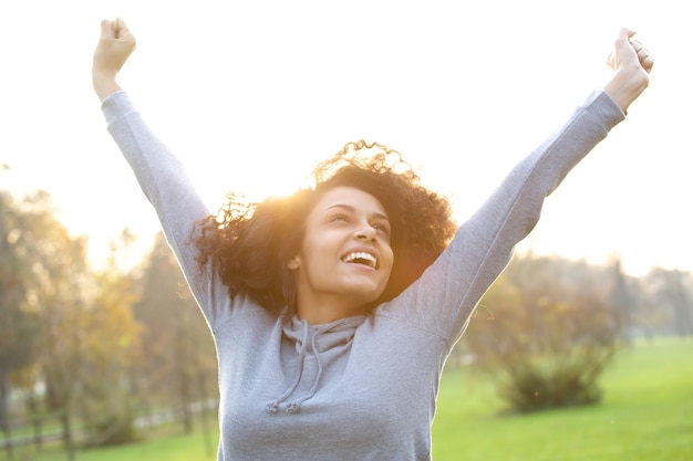Photo cheerful young woman smiling with arms raised