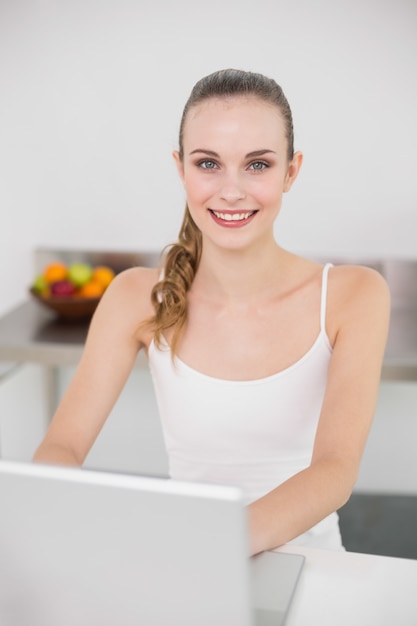 Cheerful young woman using her laptop