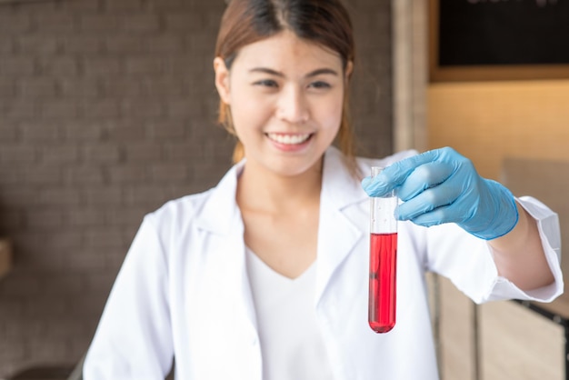 Photo cheerful young woman with chemical in test tube