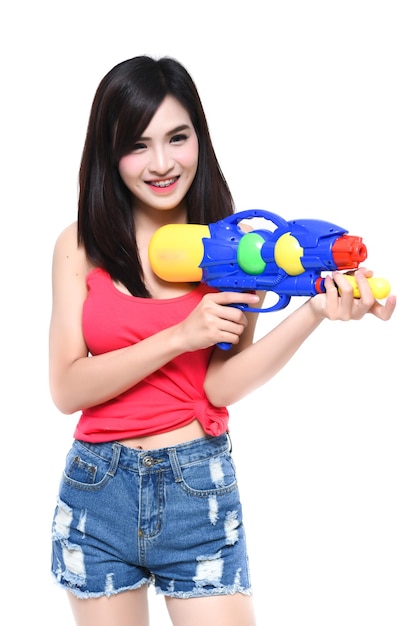 Photo cheerful young woman with squirt gun against white background