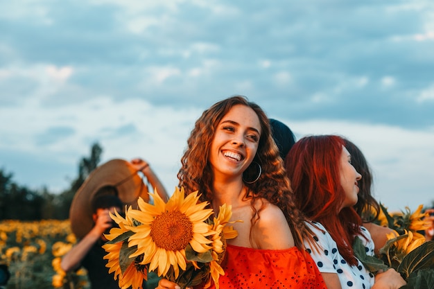 Cheerful young women in a field of sunflowers