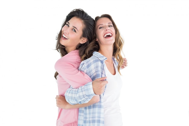 Cheerful young women standing back-to-back