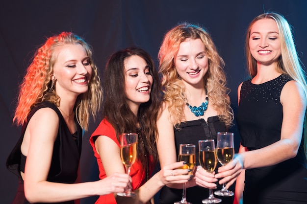 Cheerful young women with glasses of champagne at a party