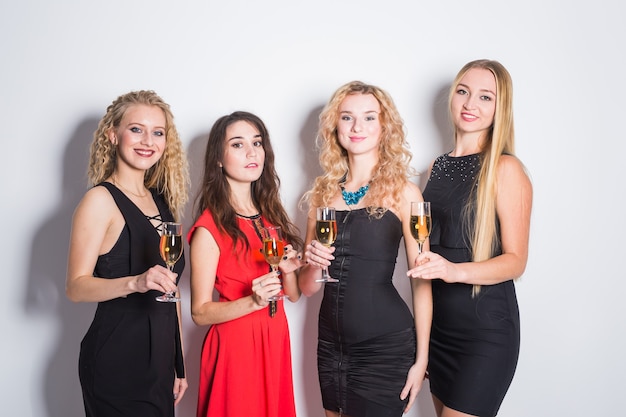 Cheerful young women with glasses of champagne at a party