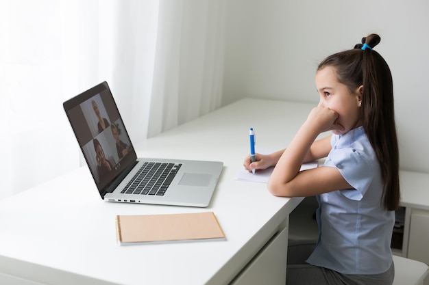 cheerfully cute girl children excited using computer learning schoolwork. kid enjoy e-learning in holiday at home.