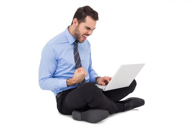 Photo cheering businessman sitting using his laptop