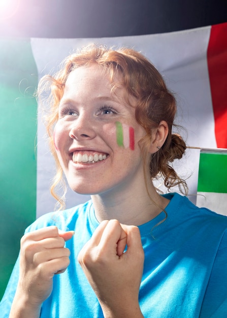 Foto donna sorridente sorridente con la bandiera italiana sul volto