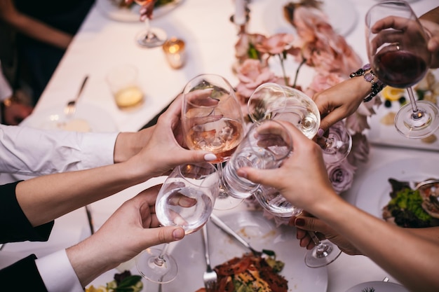 Saluti! gruppo di persone che fanno il tifo con flauti di champagne con interni domestici sullo sfondo.