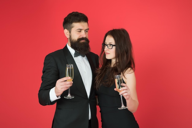 Cheers to Valentines Day Couple in love red background Sexy woman and bearded man hold champagne glasses Valentines day celebration Having party for Valentines Happy Valentines Day
