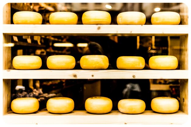 Cheese arranged on shelves for sale at store