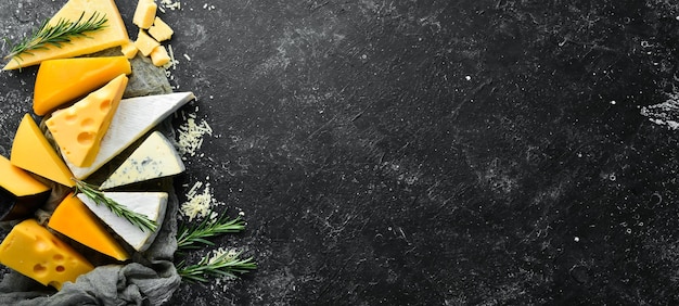 Cheese Assortment of cheese and snacks on black stone background Top view Free space for your text