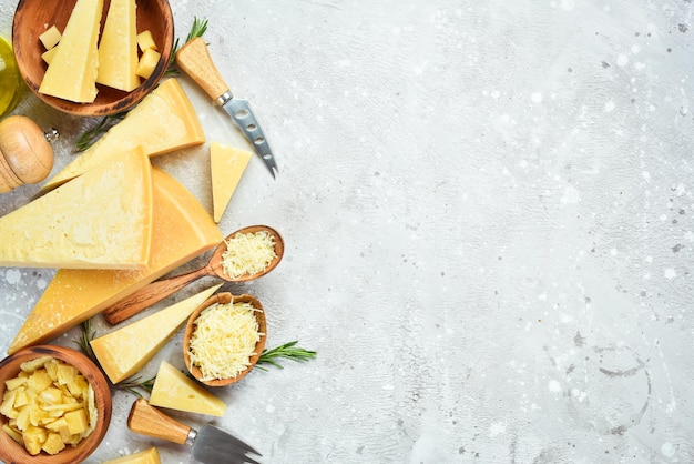 Cheese background Set of hard cheeses olives rosemary and spices Hard parmesan cheese Top view On a stone background