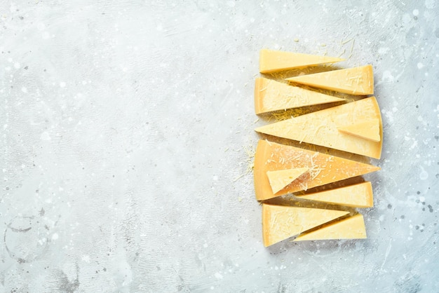 Foto sfondo di formaggio pezzi triangolari di formaggio a pasta dura su uno sfondo di pietra parmigiano spazio libero per il testo