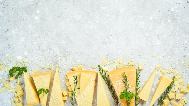 Sfondo di formaggio pezzi triangolari di formaggio a pasta dura su uno sfondo di pietra parmigiano spazio libero per il testo