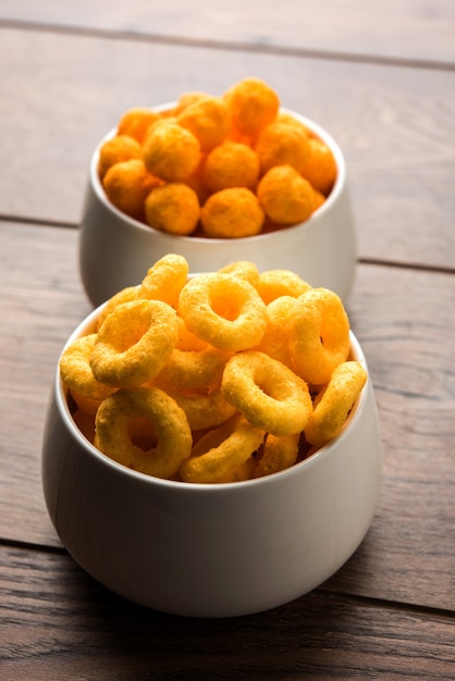 Cheese balls rings, Corn Puff with crispy salty Wheel fryums. Served in a white plate or wooden bowl. Selective focus