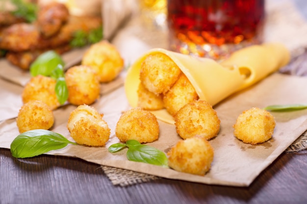 Cheese balls with basil leaves on a wooden table