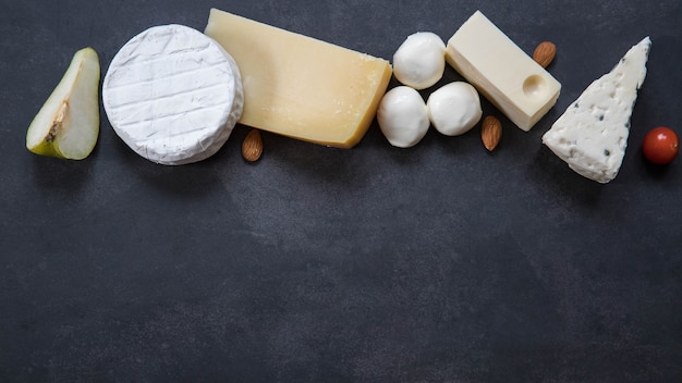 Cheese board on a black background top view with a copy space