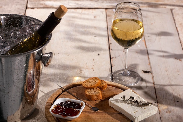 Cheese board served with marmalade and fresh white wine