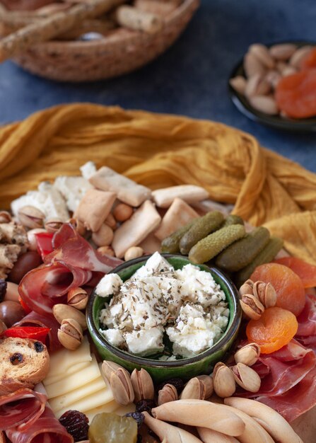 Cheese board with appetizer selection, cheese variety, cured meat, crackers, olives. Colorful meal. Top view.