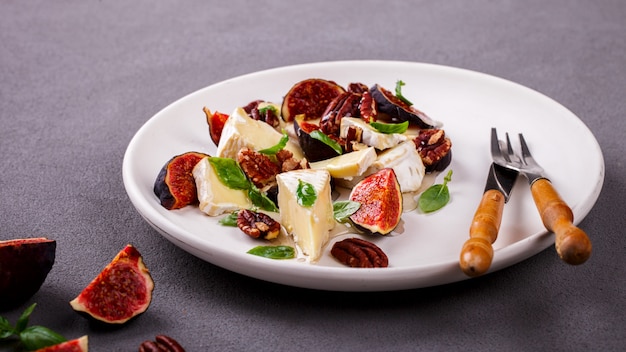 Cheese brie camembert on a plate.Snack with fresh figs