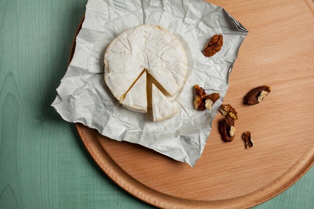 cheese brie camembert and walnuts on a wooden light background top view Camembert cheese