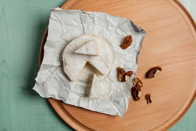 cheese brie camembert and walnuts on a wooden light background top view Camembert cheese