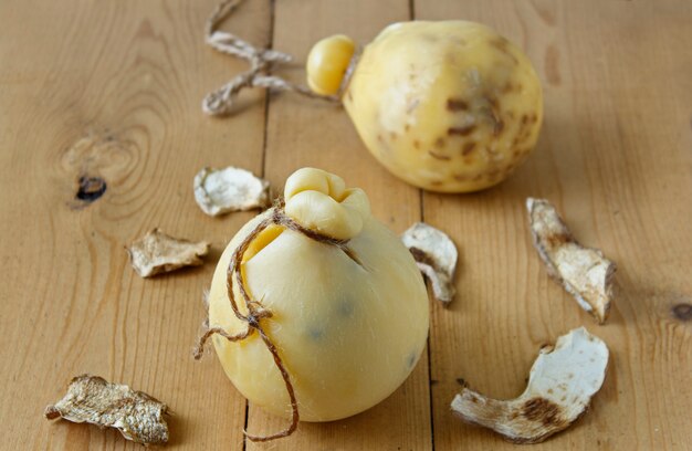 Cheese Caciocavallo with dried porcini mushrooms on a wooden background. Cheese pear