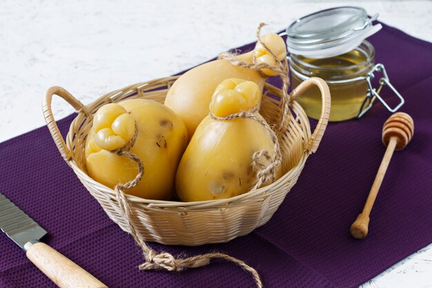 Cheese Caciocavallo with honey in a basket on a white background. Cheese pear