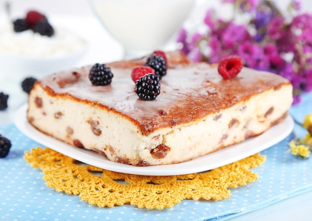 Cheese casserole with raisins on plate on napkin isolated on white