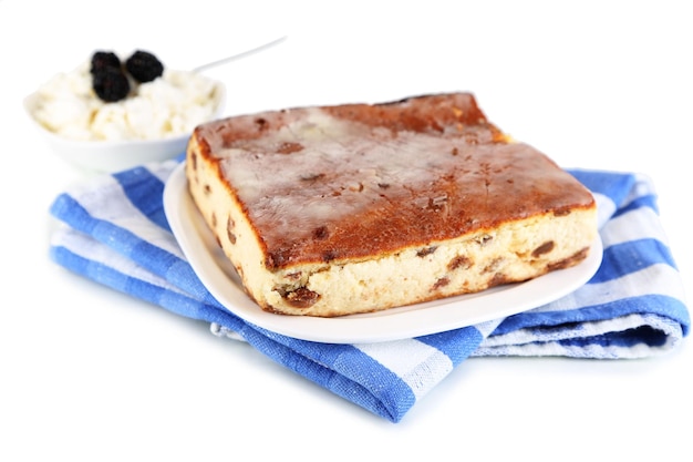 Foto casseruola di formaggio con uvetta sul piatto sul tovagliolo isolato su bianco