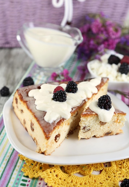 Cheese casserole with raisins on plate on napkin on wooden table closeup