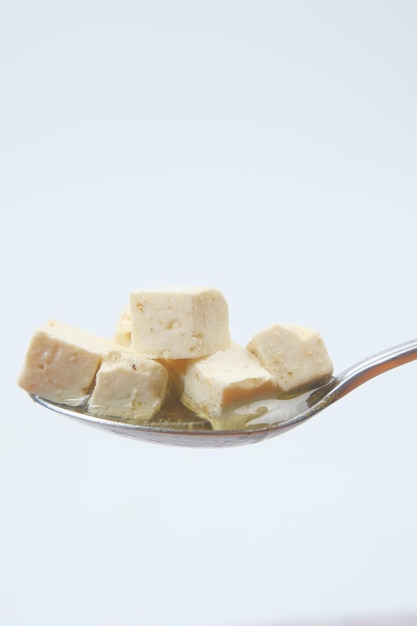 Cheese cube on a spoon close up