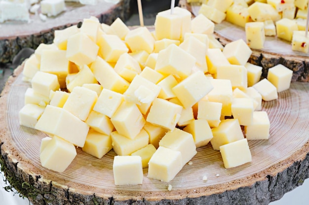 Cheese cubes on a round wooden background