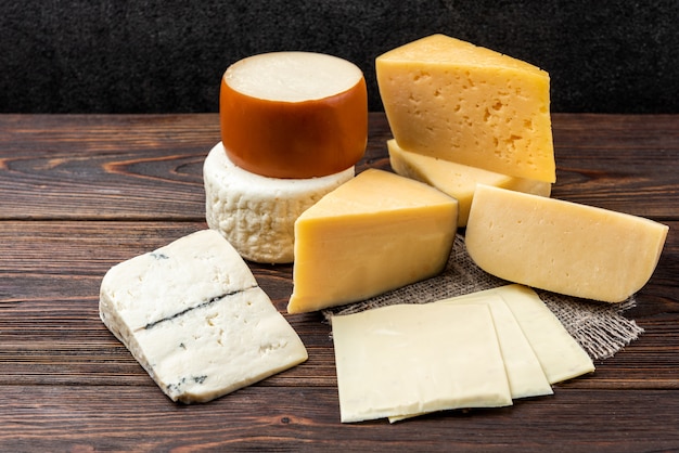 Cheese on dark wooden background.