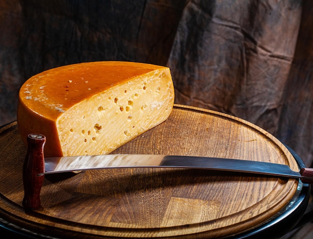 Cheese of elite variety sliced on a wooden board.